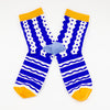 Front view of the TENGU socks. Featuring a bold blue and white pattern of playful waves, dots, and stripes, these socks bring energy and excitement to every step. The bright yellow cuff and toe add a pop of colour, while the soft blue heel keeps things stylish and unique.