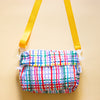Front view of Wave everyday bag. With alternate Yellow strap. Multicoloured wavy lines on a white background.