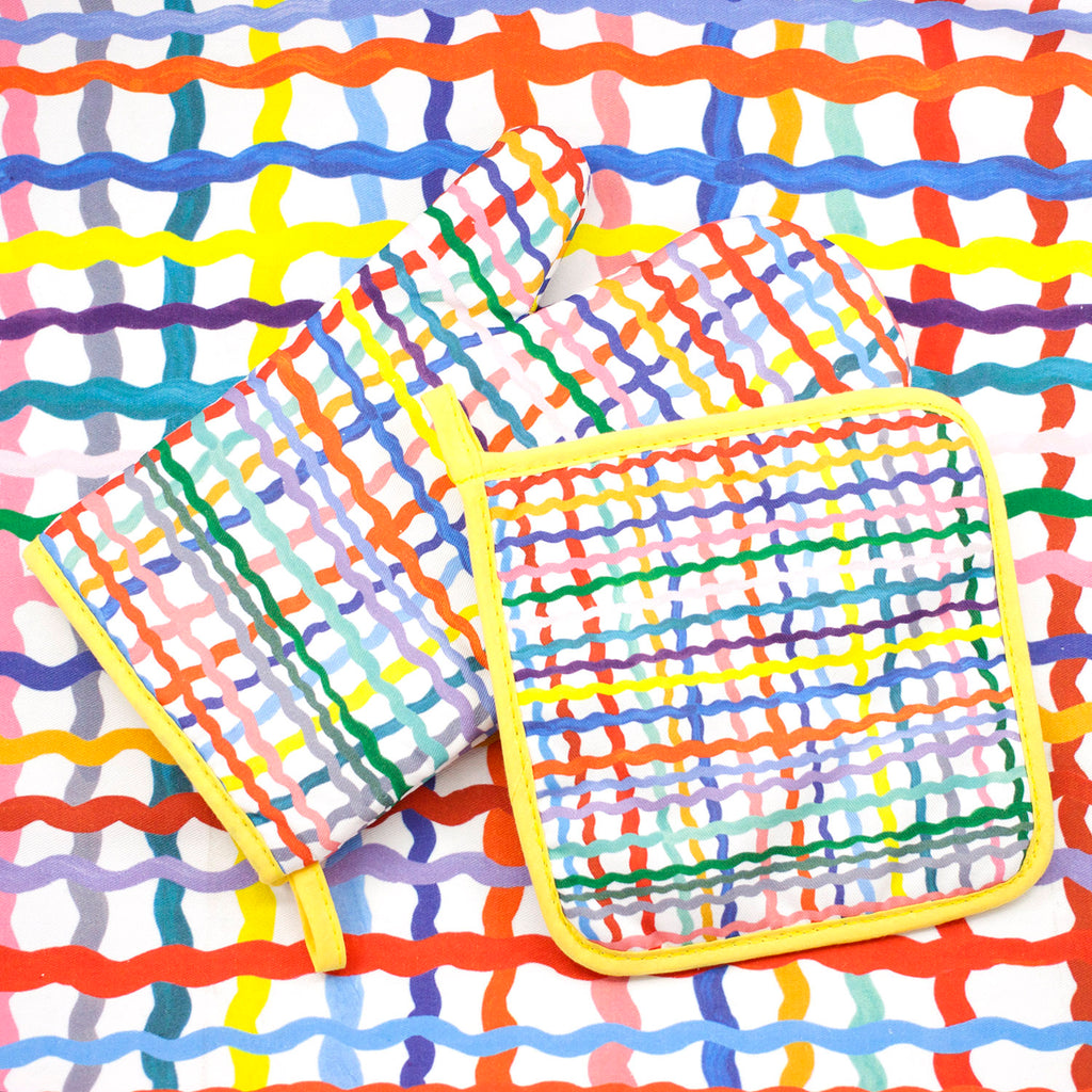 Top view of the Wave oven mitt and pot holder. Wavy multicoloured tartan pattern over a white background. 