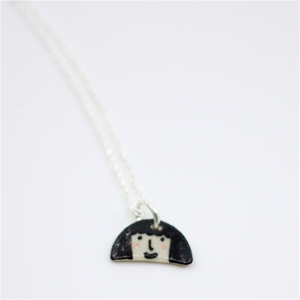Sterling silver necklace featuring a hand-painted ceramic pendant with a wavy fringe-like shape, in a colourful design, displayed on a white background.