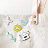 collection of shuh. pins on a bag. Including a monster, and various shapes. 